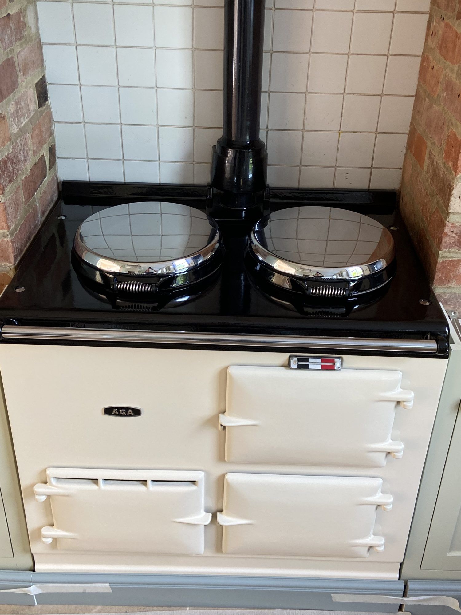 Close view of the re-enamelled cream AGA's oven doors and black top, with the two chrome hotplate lids closed
