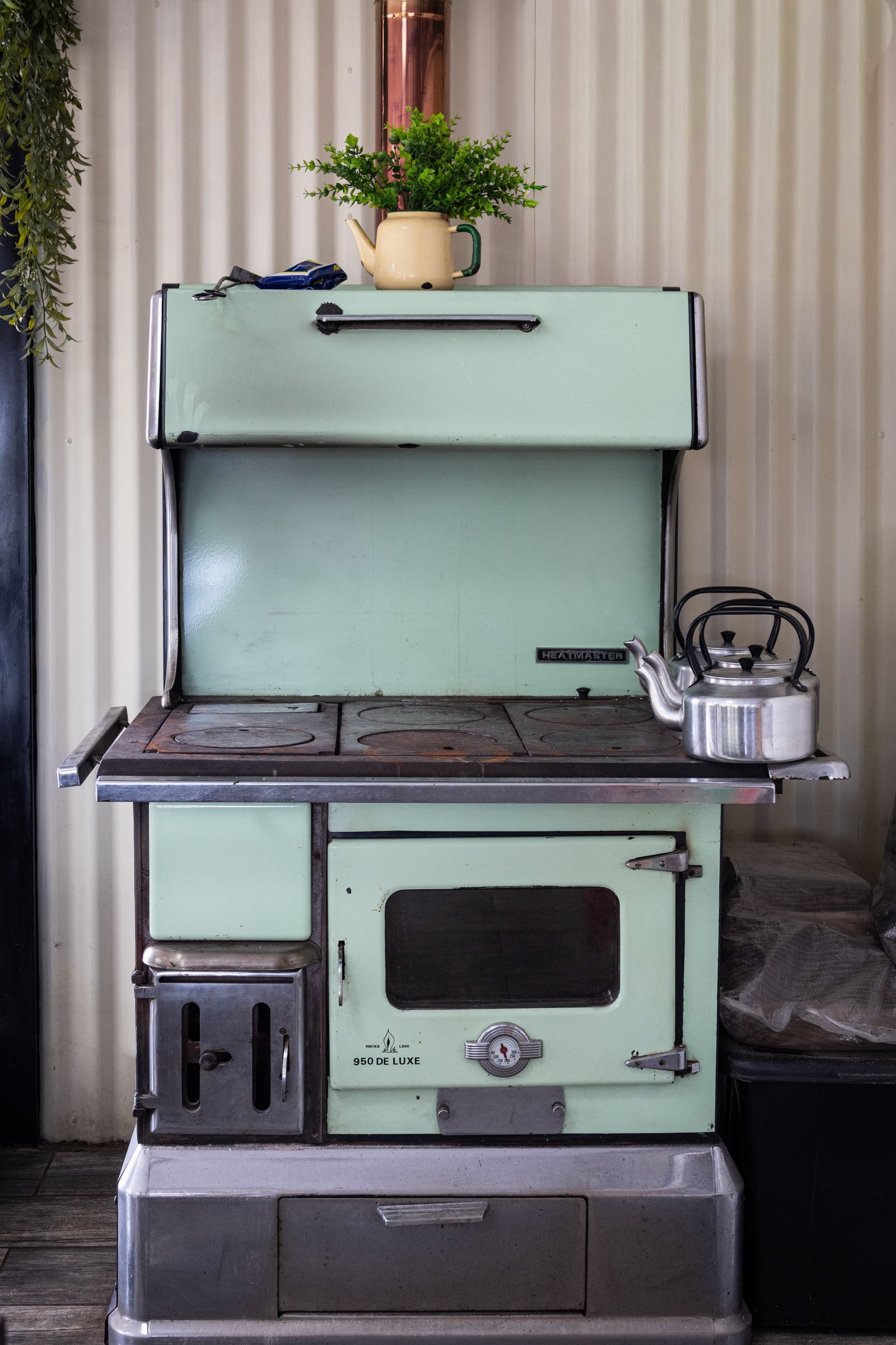 An old pale green enamelled range cooker with its enamel scuffed and worn